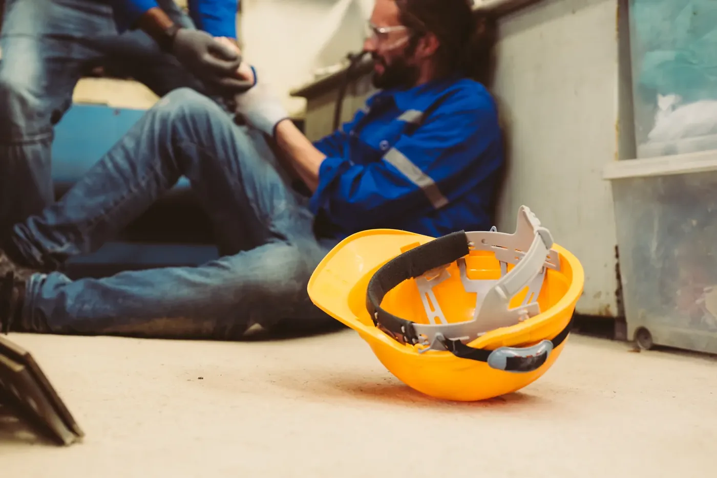 Injured worker receiving help on an industrial job site